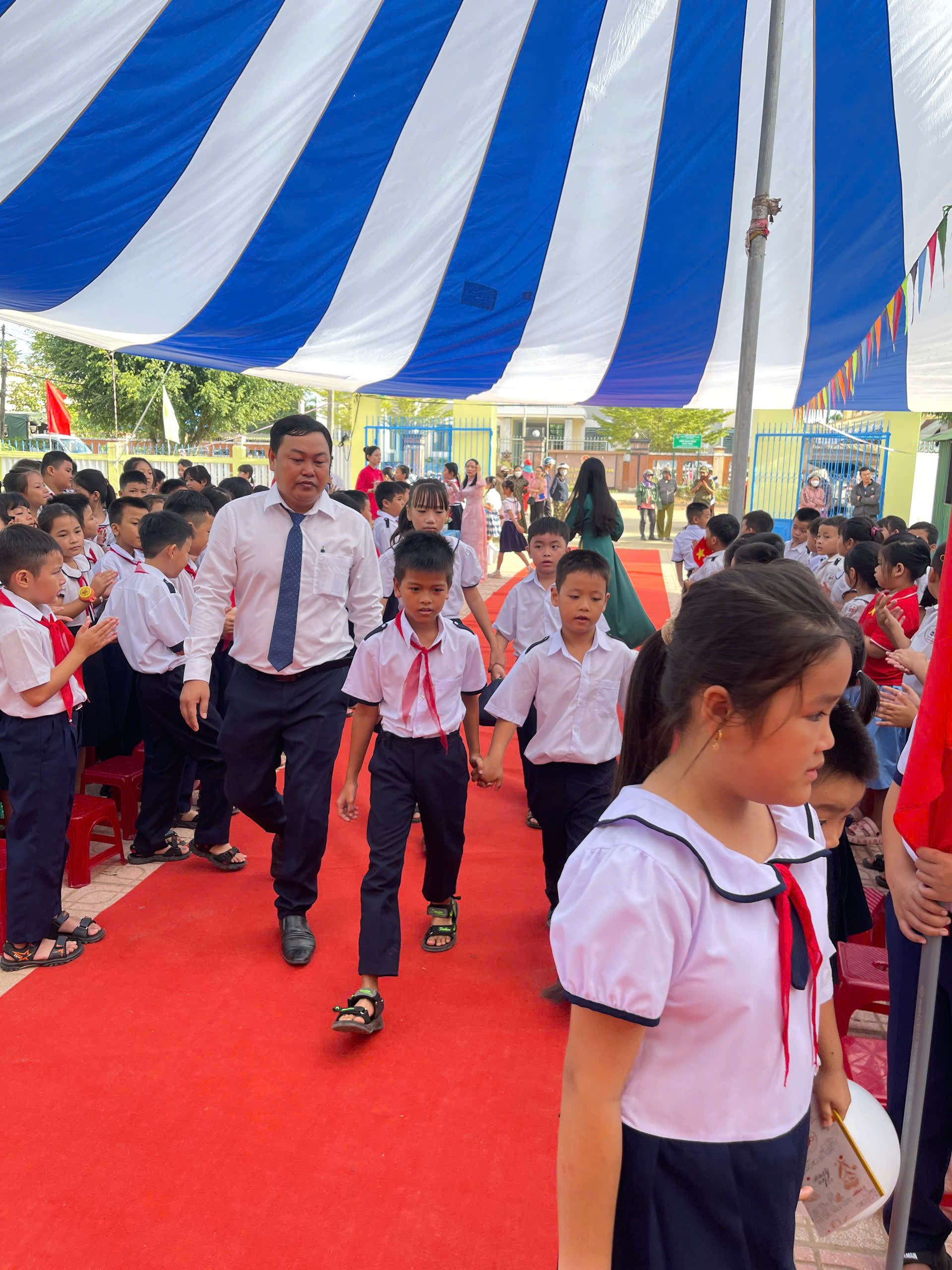 Thầy Hiệu phó cùng các em tiến vào lễ đài