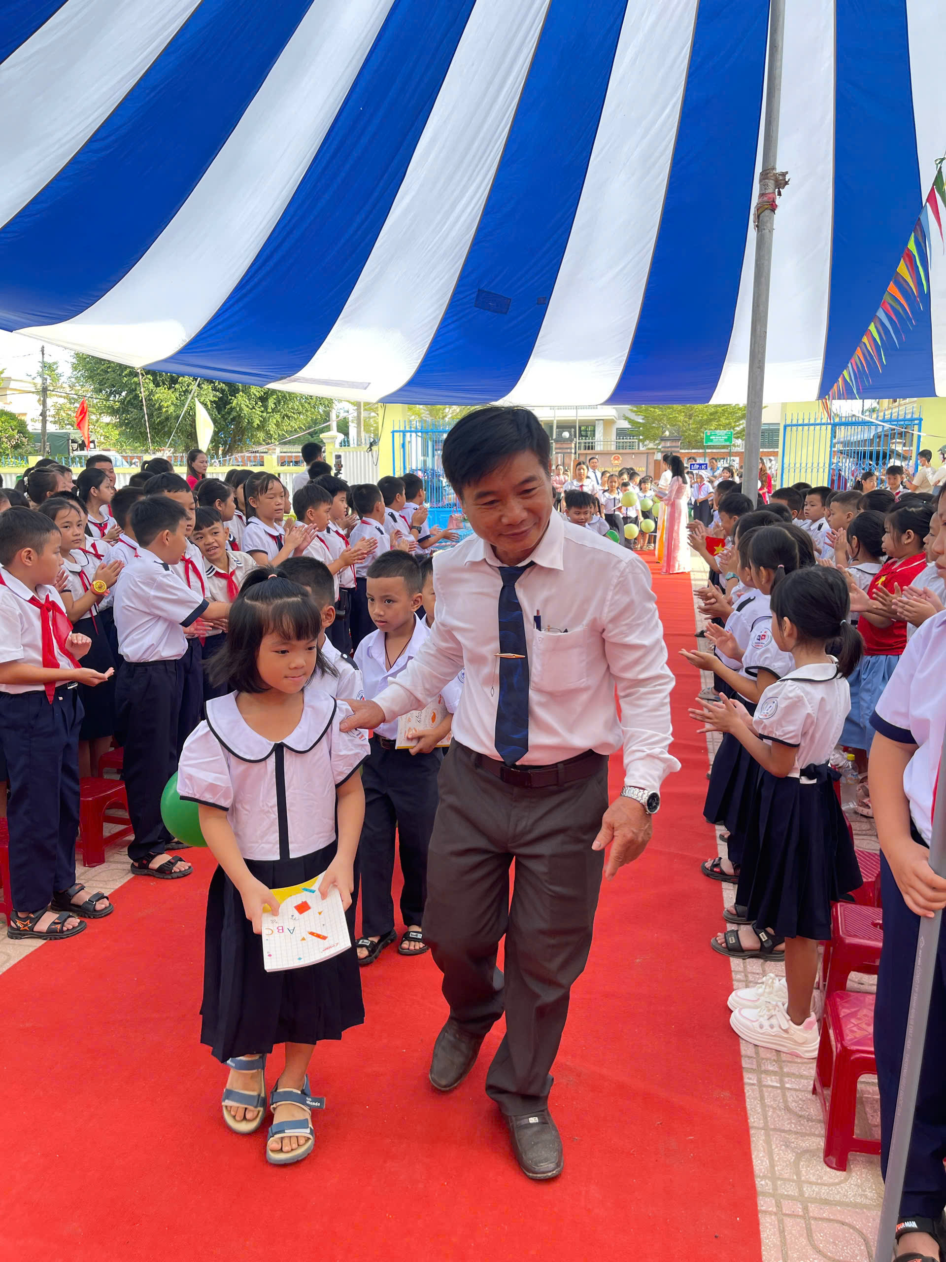 Thầy Hiệu trưởng cùng các em HS khối 1 tiến về lễ đài